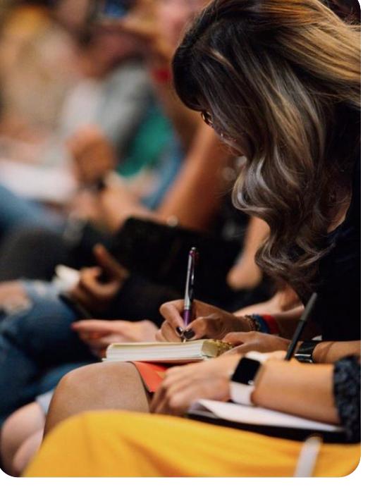 Plateia de empreendedoras fazendo anotações